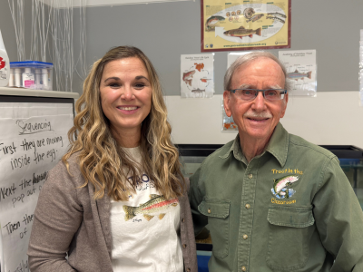 Stephanie Mitchell and Trout Unlimited volunteer Chuck Dinkel working with the Trout in the Classroom tank
